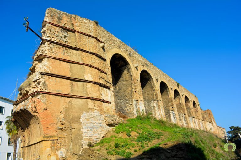 A ruined stone arcade, its piers still standing.