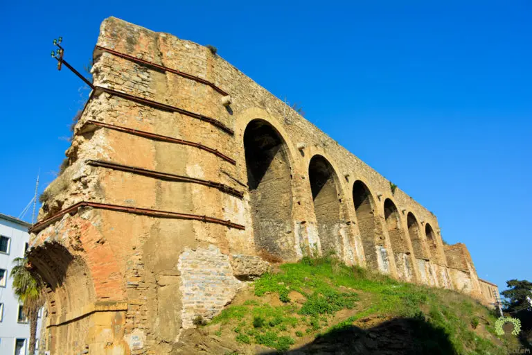 A ruined stone arcade, its piers still standing.