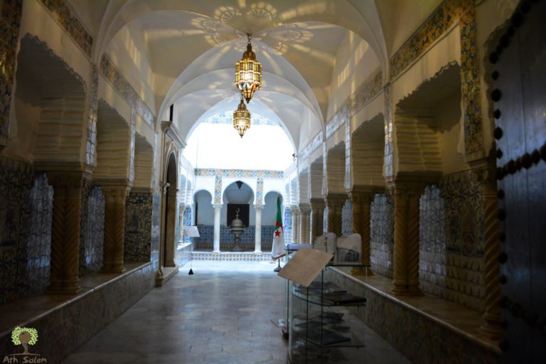 A dark arcaded corridor opening onto the light of a courtyard.