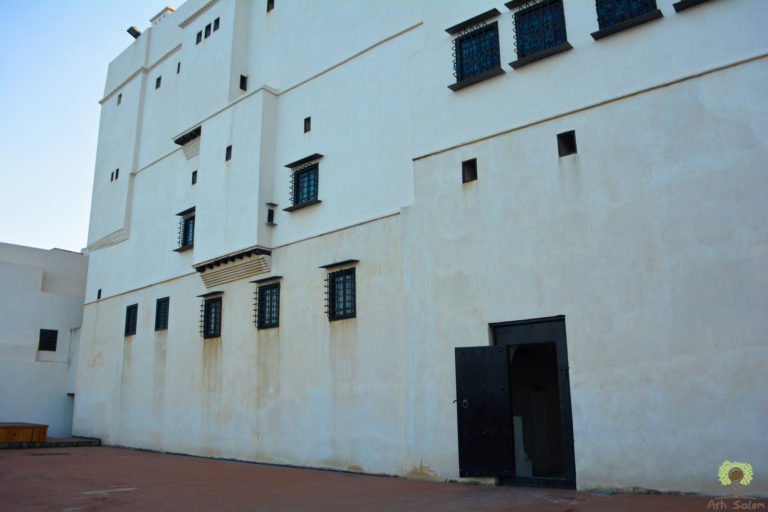 The blank outward face of a Casbah house. The street is shown a wall and a door, nothing more.