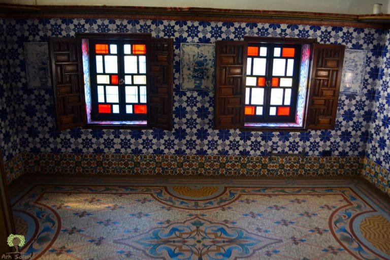 Coloured glass above a zellige floor, the light falling in patterns.