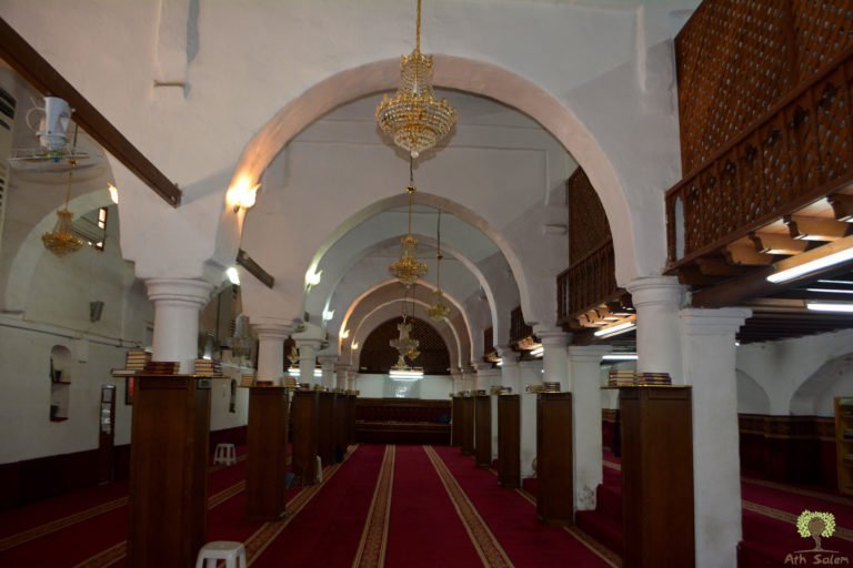 A prayer hall of arcades, the carpet running the length of it.